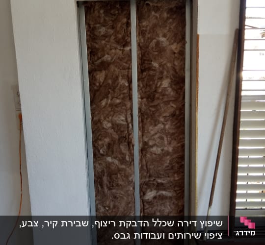 קיר עם בידוד פיברגלס במסגרת מתכת במהלך שיפוץ
